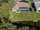 Aerial view of home with pool and screened enclosure at 498 Lake Of The Woods Dr, Venice, FL 34293