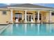 Community pool with covered patio and lounge chairs at 498 Lake Of The Woods Dr, Venice, FL 34293