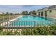 Inviting community pool with a surrounding fence and lush landscaping at 498 Lake Of The Woods Dr, Venice, FL 34293