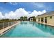 Relaxing community pool with lounge chairs and clubhouse view at 498 Lake Of The Woods Dr, Venice, FL 34293