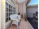 Relaxing screened porch with wicker furniture and potted plants at 498 Lake Of The Woods Dr, Venice, FL 34293