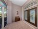 Covered front porch with tiled floor, bench, and double doors at 498 Lake Of The Woods Dr, Venice, FL 34293
