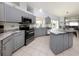 Modern kitchen with gray cabinets, stainless steel appliances, and an island at 498 Lake Of The Woods Dr, Venice, FL 34293