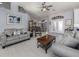 Bright living room with gray sofas, coffee table, and tile flooring at 498 Lake Of The Woods Dr, Venice, FL 34293