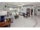 Spacious living room with gray sofas, a rocking chair, and a view of the pool at 498 Lake Of The Woods Dr, Venice, FL 34293