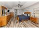 Bright main bedroom with wood furniture, a ceiling fan, and hardwood floors at 498 Lake Of The Woods Dr, Venice, FL 34293