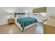 Comfortable bedroom with teal bedding and wood floors at 519 Albee Farm Rd # 115, Venice, FL 34285