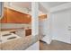 Galley kitchen with light wood cabinets and granite counters at 519 Albee Farm Rd # 115, Venice, FL 34285
