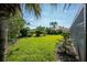 Spacious backyard with lush lawn and tropical landscaping at 521 Pennyroyal Pl, Venice, FL 34293