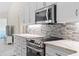 Bright kitchen features white cabinets, stainless steel appliances, and tile backsplash at 521 Pennyroyal Pl, Venice, FL 34293