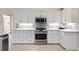 Modern kitchen with white cabinets, stainless steel appliances, and quartz countertops at 521 Pennyroyal Pl, Venice, FL 34293