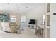 Living area with reclining sofa and adjacent kitchen at 521 Pennyroyal Pl, Venice, FL 34293