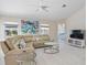 Bright living room with vaulted ceiling, large sectional sofa, and modern coffee table at 521 Pennyroyal Pl, Venice, FL 34293