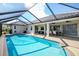 Large screened-in pool with extended patio and seating area at 521 Pennyroyal Pl, Venice, FL 34293