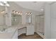 Clean bathroom with a walk-in shower, double vanity, and wood flooring at 552 Fleetwood St, North Port, FL 34287