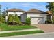 Single-story home with a tile roof, landscaped yard, and two-car garage at 5592 Semolino St, Nokomis, FL 34275
