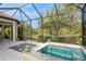 Screened-in pool and spa with a view of tropical landscaping at 5592 Semolino St, Nokomis, FL 34275