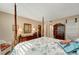Spacious bedroom with four-poster bed and ensuite bath at 649 Tamiami S Trl # 107, Venice, FL 34285