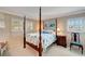 Charming bedroom with a four-poster bed and window shutters at 649 Tamiami S Trl # 107, Venice, FL 34285