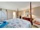 Bedroom with four-poster bed, barn door, and ensuite bath at 649 Tamiami S Trl # 107, Venice, FL 34285