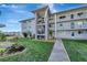 Exterior view of condo building with walkway and landscaping at 649 Tamiami S Trl # 107, Venice, FL 34285