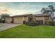 Exterior view of a charming villa with a well-manicured lawn and two-car garage at 652 Linden Dr, Englewood, FL 34223