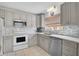 Modern kitchen with gray cabinets, white appliances, and tile backsplash at 652 Linden Dr, Englewood, FL 34223