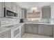 Modern kitchen with gray cabinets, white appliances, and tile backsplash at 652 Linden Dr, Englewood, FL 34223