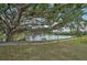 Serene walkway along lake with bench under large oak tree at 652 Linden Dr, Englewood, FL 34223