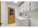 Bright laundry room with washer, dryer, and storage cabinets at 652 Linden Dr, Englewood, FL 34223