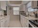 Modern kitchen with white cabinets, stainless steel appliances, and granite counters at 6796 Gasparilla Pines Blvd # 13, Englewood, FL 34224