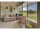 Relaxing sunroom features comfy seating and large windows offering garden views at 6796 Gasparilla Pines Blvd # 13, Englewood, FL 34224