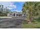 Modern home with a two-car garage and a circular driveway, surrounded by palm trees at 6813 Pitomba St, North Port, FL 34286