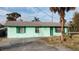 Light teal single story home with a driveway and mature landscaping at 810 Texas St, Englewood, FL 34223