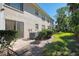 Back patio and yard with AC units and lush landscaping at 817 Montrose Dr # 103, Venice, FL 34293
