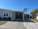Close-up of the house with a covered, screened-in lanai and paved driveway under a clear blue sky at 874 Baveno Dr, Venice, FL 34285