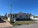 Well-maintained home with an enclosed lanai, manicured lawn, and lovely landscaping under a clear blue sky at 874 Baveno Dr, Venice, FL 34285