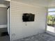Screened lanai featuring a mounted television and a sliding barn door for privacy and entertainment at 874 Baveno Dr, Venice, FL 34285