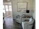 Cozy seating area with two armchairs, a side table with lamp, and neutral decor at 874 Baveno Dr, Venice, FL 34285