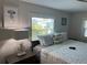 Cozy bedroom showcasing a comfortable bed, side tables, and natural light from the window at 874 Baveno Dr, Venice, FL 34285
