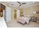 Bedroom with carpeted floor, ensuite bathroom, and ceiling fan at 10319 Medjool Dr, Venice, FL 34293