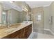 Elegant bathroom with double sinks, granite countertops, and a large glass shower at 10457 Crooked Creek Dr, Venice, FL 34293