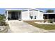 Gray manufactured home with covered carport, landscaping, and a paved driveway at 113 Lakeview Dr, North Port, FL 34287