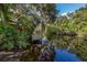 Kayaks are stored on a rack near a wooden dock extending over a calm waterway at 1226 Pine Needle Rd, Venice, FL 34285