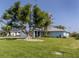 House exterior showcasing a large tree and green lawn at 1226 Pine Needle Rd, Venice, FL 34285