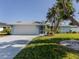 Light blue house with white garage door and landscaped lawn at 1226 Pine Needle Rd, Venice, FL 34285