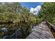 Long wooden dock extends over calm water, offering peaceful waterfront views at 1226 Pine Needle Rd, Venice, FL 34285