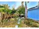 Landscaped backyard with stone pathway and tropical plants at 1237 Schooner Ln, Venice, FL 34285