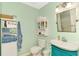 Charming bathroom with teal vanity, white fixtures and a white shelf at 1237 Schooner Ln, Venice, FL 34285