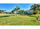 Light blue house with a large yard, palm trees, and driveway at 1237 Schooner Ln, Venice, FL 34285
